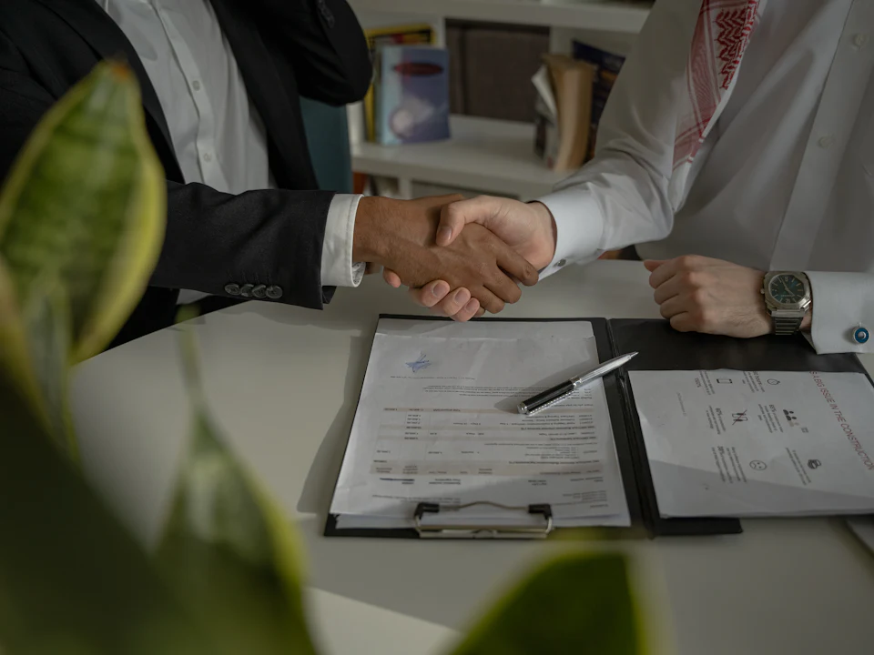 Handshake over signed documents at a meeting