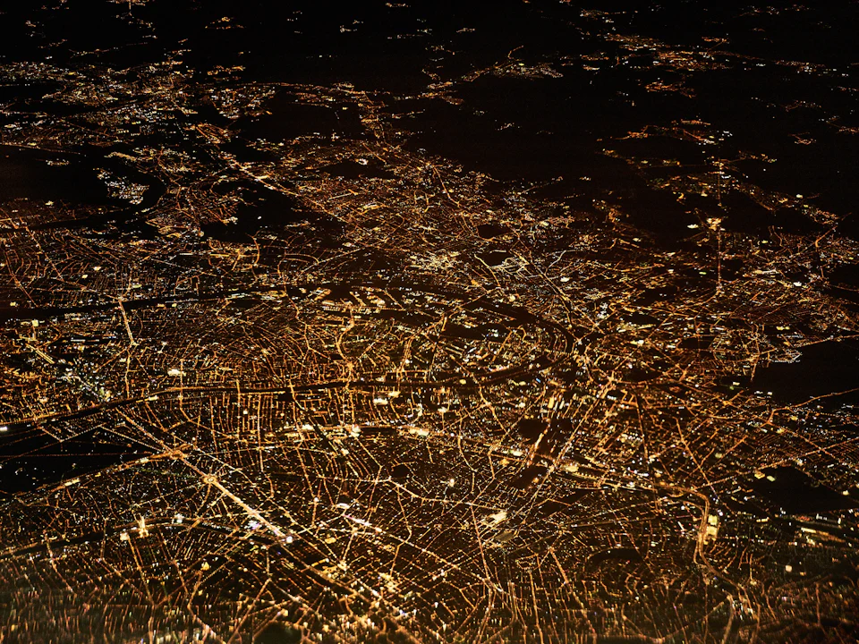 Aerial view of a city glowing with golden lights at night